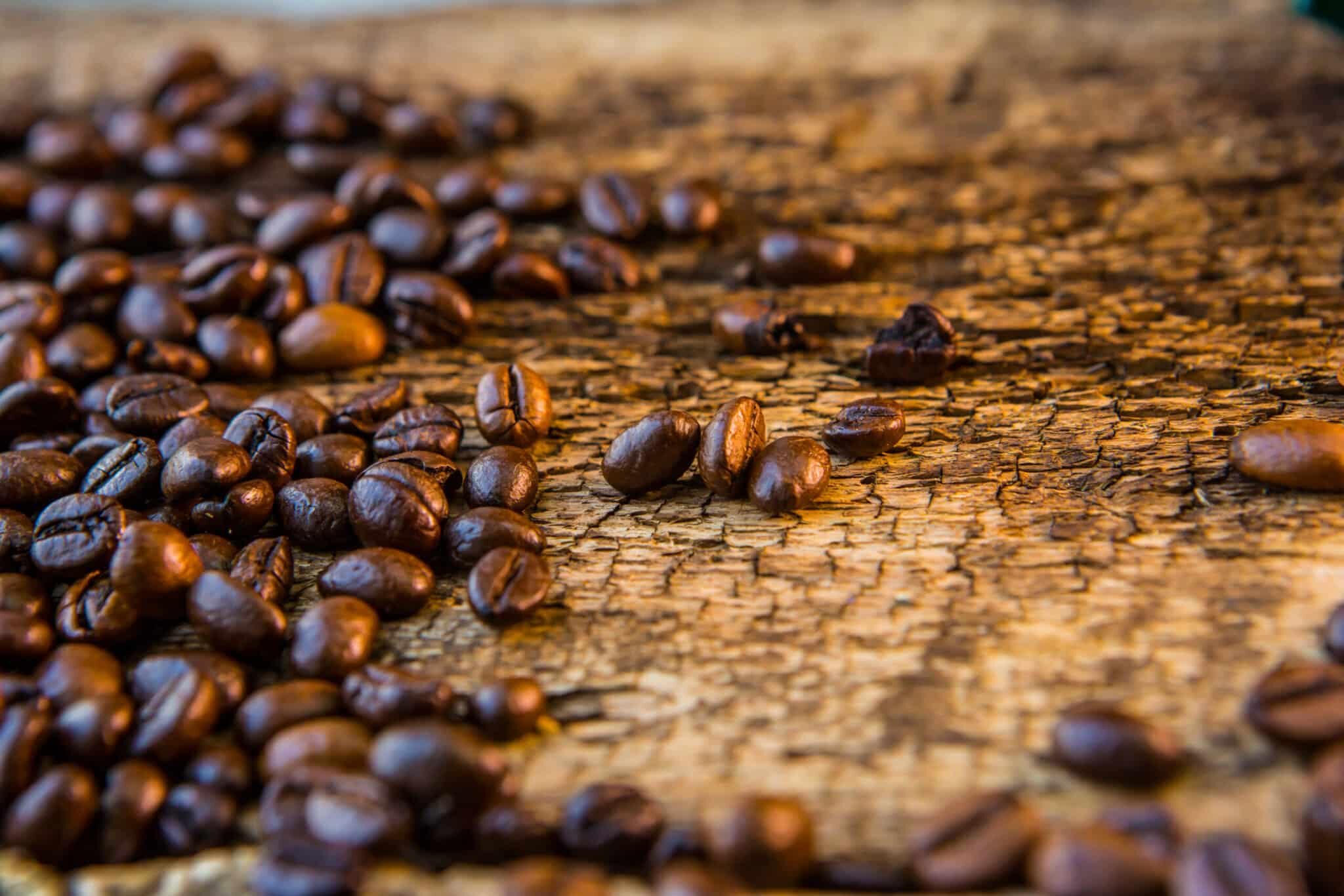 Coffee beans on wood texture background.